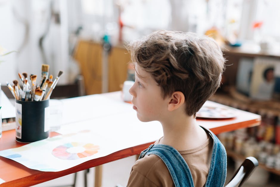 A young boy immersed in painting at a bright and cozy art studio, showcasing creativity.