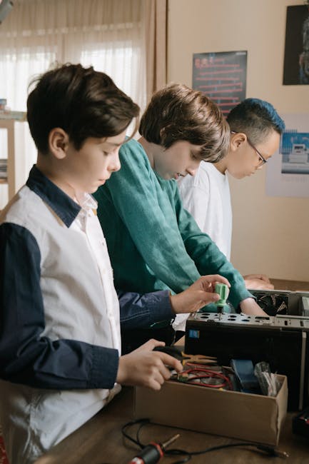 Children explore computing by assembling computer parts indoors.